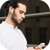 Happy Deriv partner holding mobile phone and managing affiliate dashboard