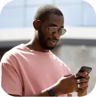 User holding a smartphone with Deriv’s trading dashboard on screen