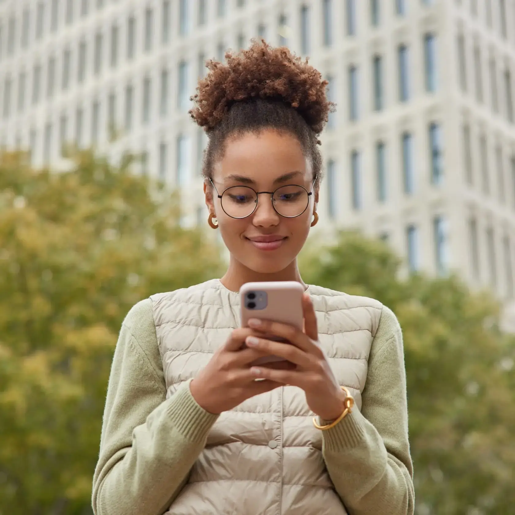 Man using smartphone for gold trading with Deriv in urban setting