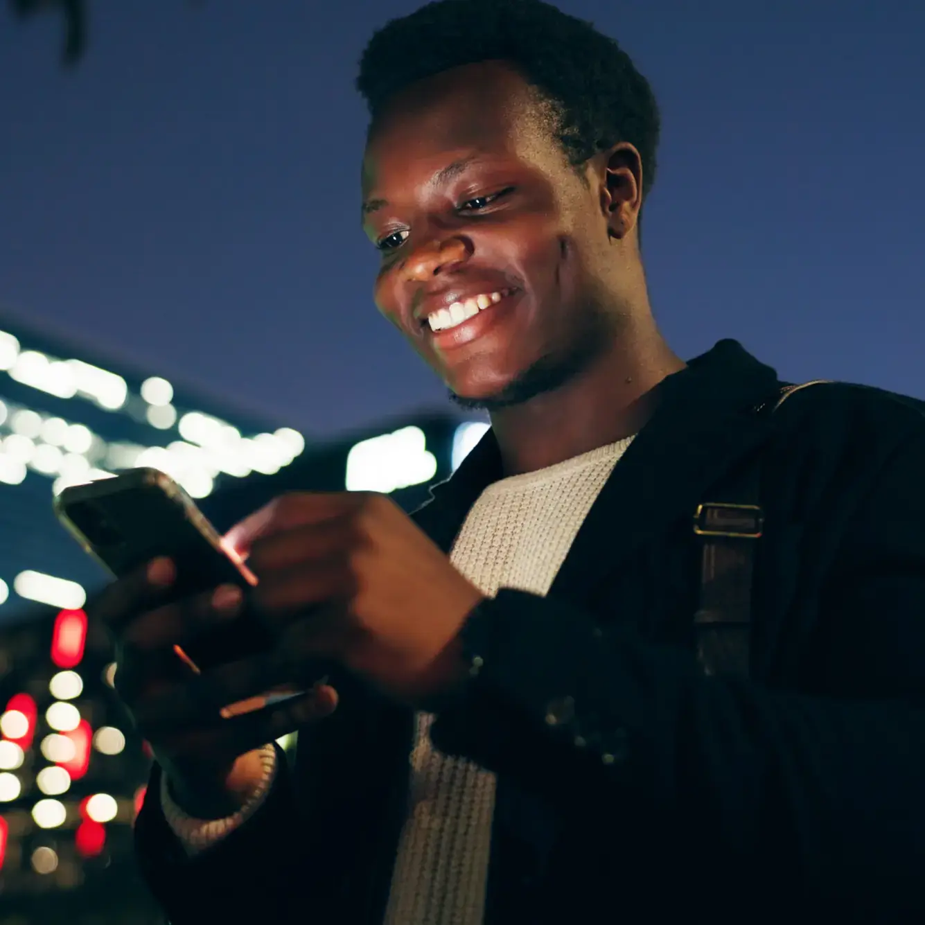 A young trader using mobile device for Bitcoin trading at night